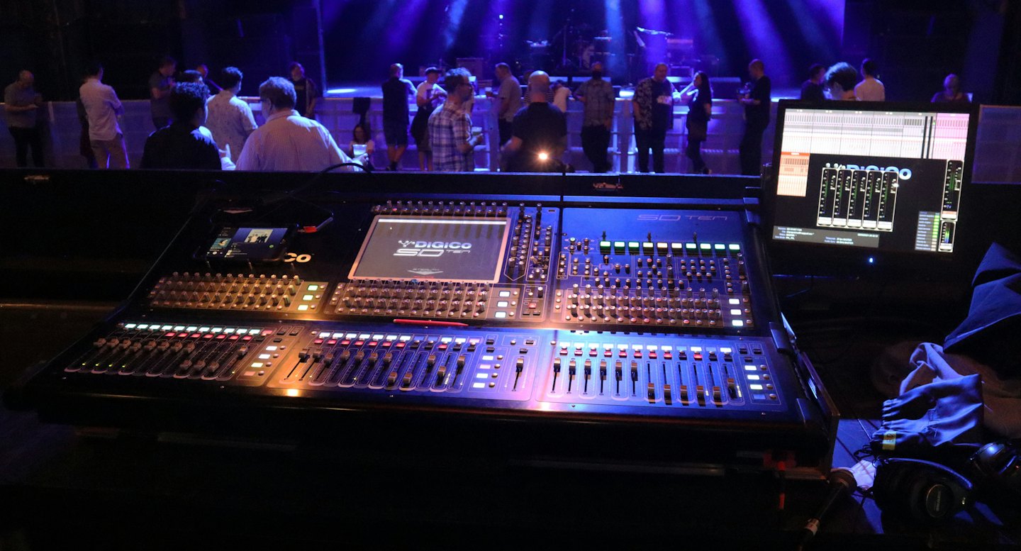 Digitale Audiokonsole und Computermonitor in einem Konzertsaal.