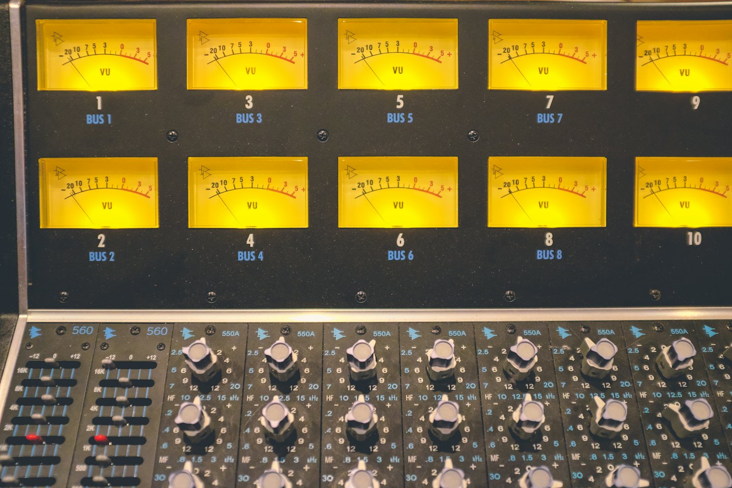 Audio-Mischpult mit beleuchteten gelben VU-Metern.