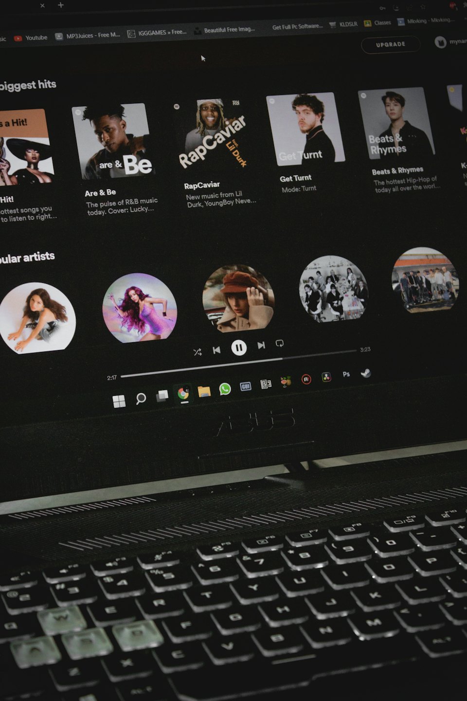 Laptop-Bildschirm mit Musik-Streaming-Dienst und geöffneten Browser-Tabs.